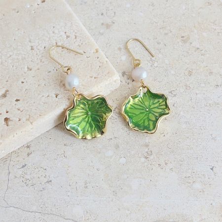 A pair of green lotus leaf earrings showcasing the elegant gold hooks and pearl details.