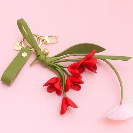 Red orchid keychain displayed on a pink background.