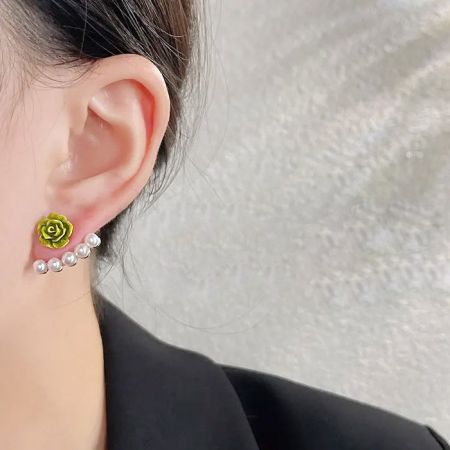 緑のバラとパールスタッドイヤリングを着用しているクローズアップ。