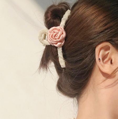 ピンクの椿のヘアクローを髪に使ったモデル。