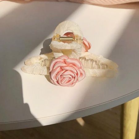 ピンクの布製椿のヘアアクセサリーの斜めからのビュー。