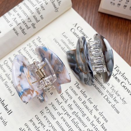 Two acetate hair clips with a beautiful marbled design, showing the claw mechanism.