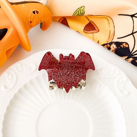 Close-up of a red glitter bat wing hair clip.