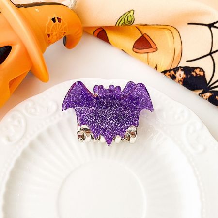 Vibrant purple glitter bat hair clip, a perfect Halloween accessory.