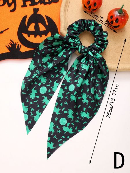 Gedetailleerd uitzicht op een groene en zwarte Halloween scrunchie met heks-, vleermuis- en kattenontwerpen.
