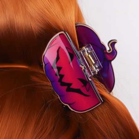 Close-up van een jack-o'-lantern Halloween haarclip gedragen in rood haar.
