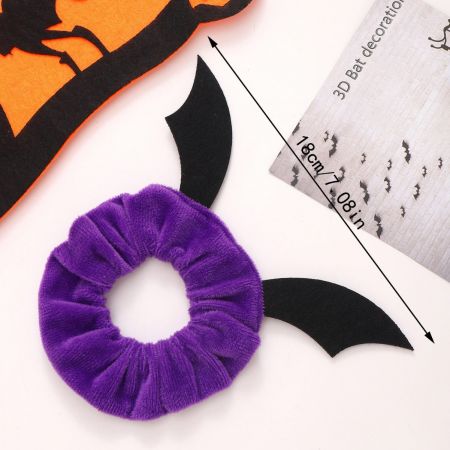 Um scrunchie de Halloween roxo vibrante com asas de morcego decorativas.