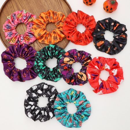An assortment of colorful Halloween scrunchies made from soft satin material.