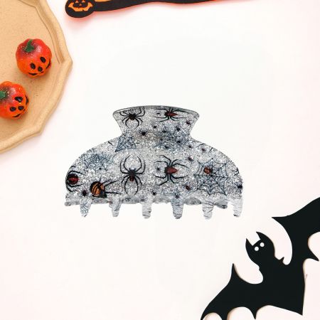 Detaillierte Ansicht einer klaren Halloween-Haarklammer mit einem schwarzen Spinnen- und Netzmuster.