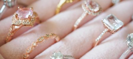 A hand displaying a variety of vibrant gemstone rings, available for private label and wholesale.