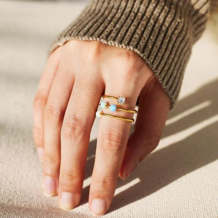 Das Starlit Ocean mehrschichtige Ring-Set in luxuriösem Gold-Finish, getragen an der Hand eines Modells.