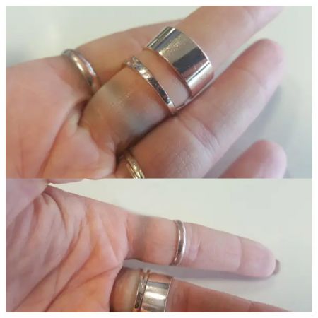 Uma mão adornada com múltiplos anéis de aço inoxidável estilosos e hipoalergênicos.