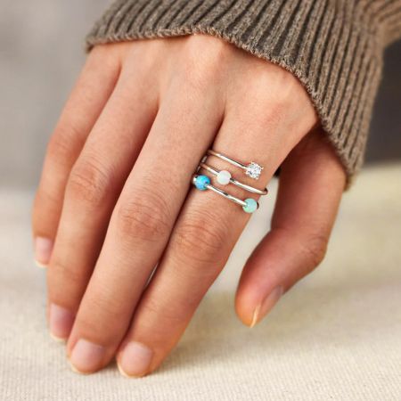 Eine Nahaufnahme der mehrschichtigen Silberopalringe an einer Hand, die das filigrane Design zeigt.