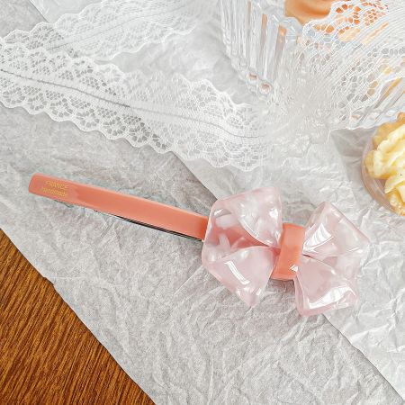 A delicate pink handmade French-style bow hair clip.
