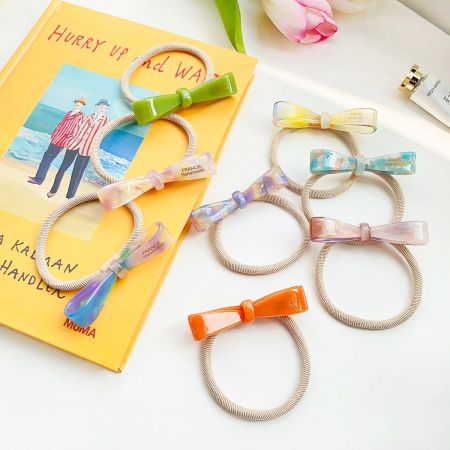 Een collectie handgemaakte acetaat haarbandjes met strikken in verschillende kleuren, uitgestald op een witte ondergrond.