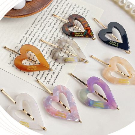 Close-up of handmade heart-shaped hair clips from France in various colors and patterns.