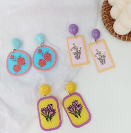 Tres pares de pendientes de arcilla polimérica hechos a mano que muestran intrincados diseños florales.