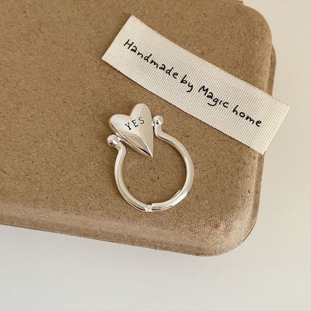 Close-up of a silver-plated adjustable brass ring featuring a heart design with 'YES' engraved.