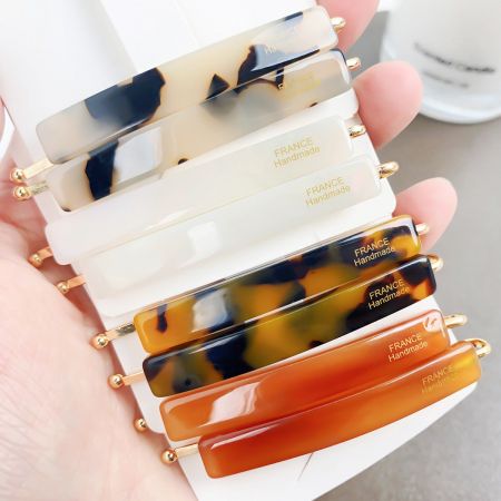 Close-up of handmade tortoiseshell acetate hair clips with elegant gold accents.