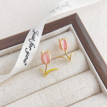 Prise de vue détaillée mettant en avant la qualité artisanale des boucles d'oreilles en forme de tulipe.