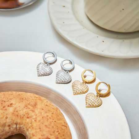 Pendientes de aro de zirconia en forma de corazón para mujeres, joyería de caída de acero inoxidable chapada en oro PVD (5 pares) - Una exhibición de pendientes de aro de zirconia en forma de corazón tanto en acero inoxidable chapado en oro PVD como en plata, mostrando los encantos en forma de corazón brillantes sobre una superficie blanca limpia.