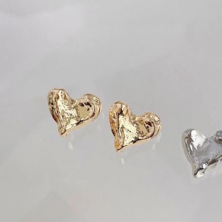金と銀のハート型イヤリング、汎用性のある魅力を強調。