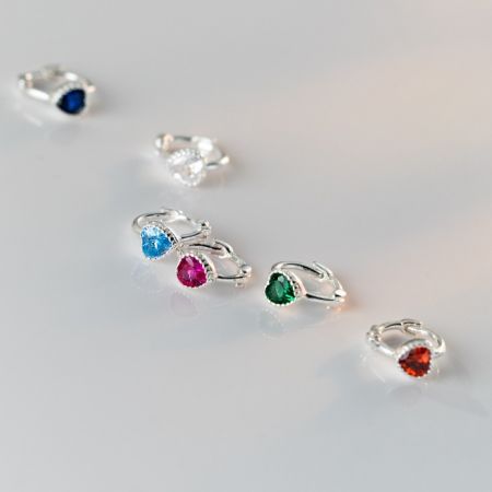 Boucles d'oreilles en argent sterling 925 avec pierres CZ colorées - Une collection de boucles d'oreilles en argent sterling 925 présentant des pierres en zircon cubique interchangeables dans diverses couleurs vives, y compris le rouge, le bleu, le vert et le transparent.