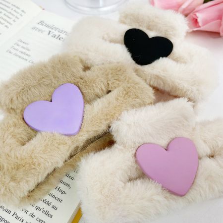 Una variedad de clips de pelo esponjosos con decoraciones de corazón en rosa, púrpura y negro.