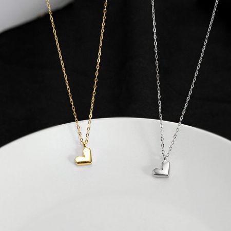 Collar Minimalista en Forma de Corazón de Plata Esterlina 925 - Un conjunto de collares minimalistas en forma de corazón en acabados de plata esterlina 925 y oro, exhibidos uno al lado del otro.