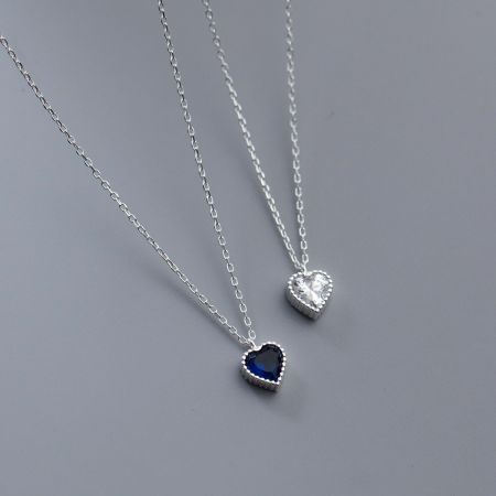 Vue détaillée des pendentifs en zircon bleu et clair en forme de cœur sur des chaînes en argent.