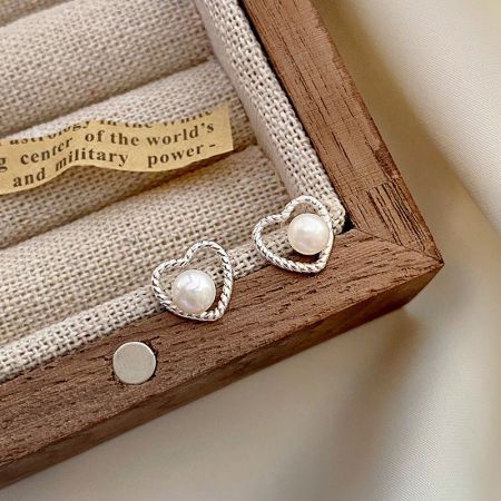 Un paio di orecchini a perno a forma di cuore vuoto in argento sterling 925 con intricati telai intrecciati.