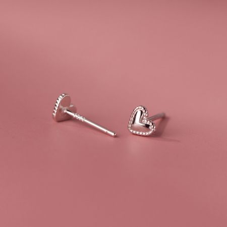 Scatto dettagliato dell'orecchino a cuore in argento, mostrando sia il design frontale che il perno dell'orecchino.