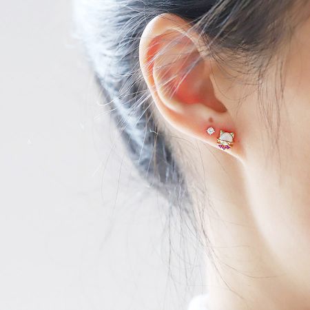 Orecchini a bottone a forma di gatto carini in argento sterling 925 con pietra di opale all'ingrosso (5 paia). - Una vista ravvicinata di una donna che indossa un carino orecchino a bottone a forma di gatto in argento sterling 925 con una pietra di opale scintillante.