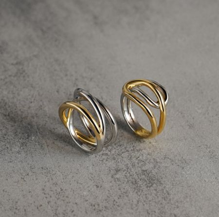 Gedetailleerd uitzicht op de twee-tone kruisring, met nadruk op de gouden en zilveren plating.