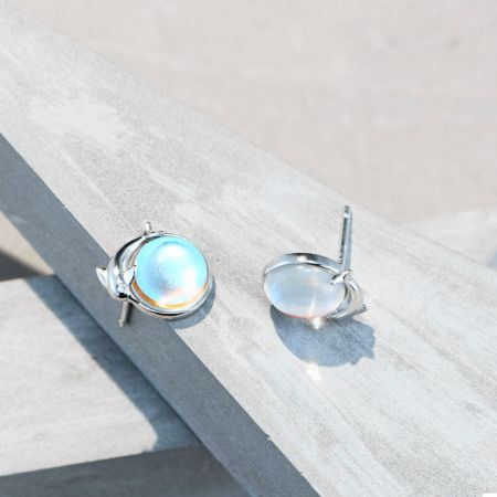 La vista posteriore degli orecchini a bottone in argento con pietra di luna a forma di delfino, mostrando il perno e il retro.