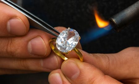 Ein geschickter Juwelier, der sorgfältig einen maßgeschneiderten Ring anfertigt und den Herstellungsprozess bei JR Fashion Accessories hervorhebt.
