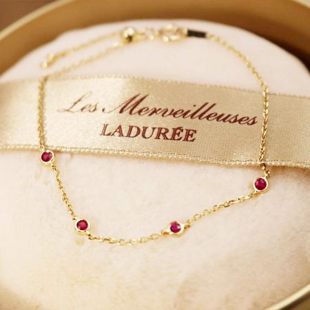 Vista dettagliata della catena e della chiusura in tono dorato del bracciale in argento sterling con pietra preziosa rossa.