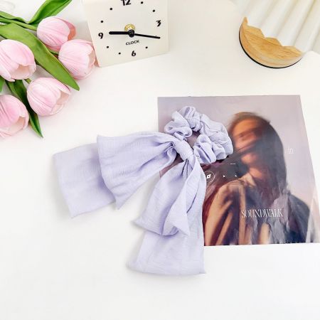 Primo piano del fermaglio per capelli a nodo di nastro lavanda.