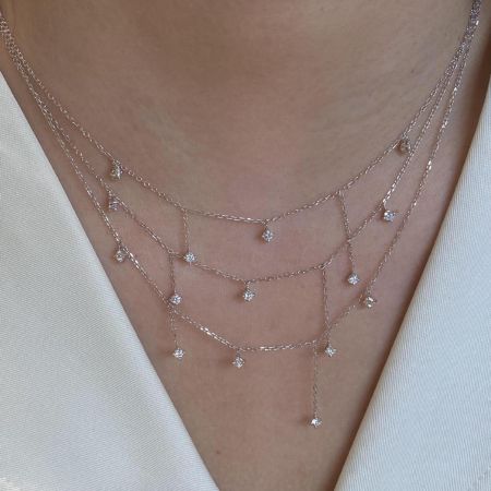 Una presentazione splendidamente stratificata della collana con pendente a nappina, evidenziando la sua versatilità.