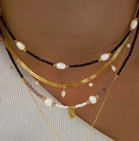 Collar de cuentas de acero inoxidable - Una vista en primer plano de un modelo que lleva el elegante collar de cuentas de acero inoxidable chapado en oro, mostrando su diseño en capas y finos detalles.
