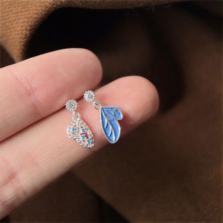 ユニークなイヤリングの全体像、涙型と青い葉のチャームの組み合わせを展示。
