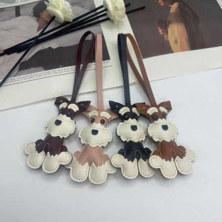 Une collection de quatre porte-clés en cuir de chien Schnauzer de différentes couleurs.