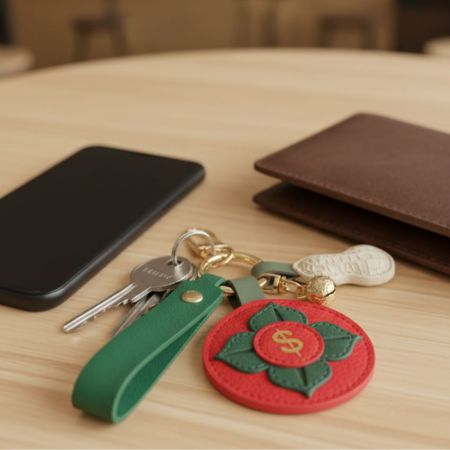Lifestyle view of the PU leather keychain collection displayed with a wallet and keys on a wooden surface.