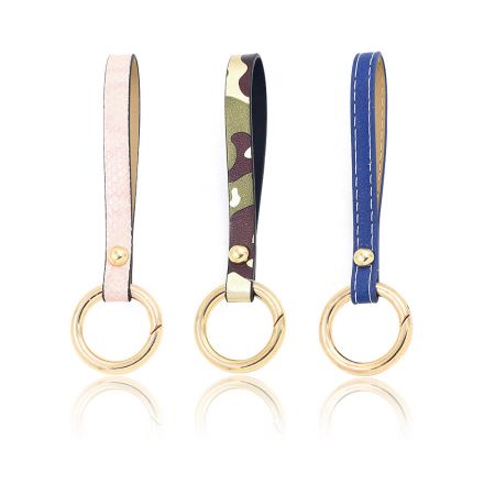 Llave con correa de muñeca - Tres llaveros con correa de muñeca de cuero PU en diferentes colores, cada uno con un elegante llavero dorado, perfecto para complementar billeteras o bolsos.