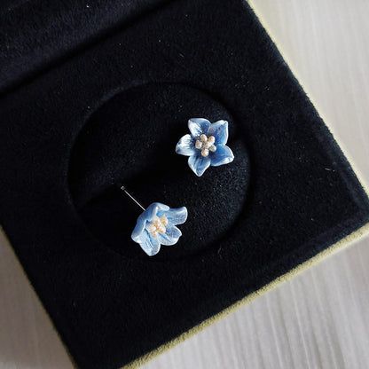 黒のベルベットライニングのジュエリーボックスに展示された花柄スタッドイヤリング。