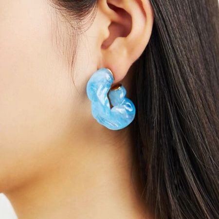 Side profile of a model wearing the light blue C-shape stud earring.