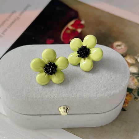 夏のフレッシュスタイルの緑のエナメルデイジー花のスタッドイヤリング(5ペア) - 白いハート型のジュエリーボックスに優雅に展示された夏のフレッシュな緑のエナメルデイジー花のスタッドイヤリングのペア。