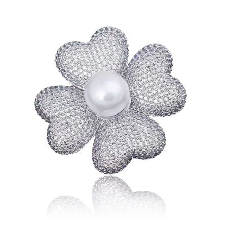 Broche de trébol con strass y perla - Un primer plano del broche de trébol con strass, que muestra sus cuatro pétalos de zirconia cúbica brillantes, una perla blanca central y un acabado de latón chapado en rodio pulido.