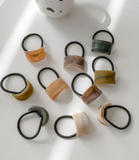 A variety of fashionable hair ties featuring marbled stone-like covers in multiple colors.