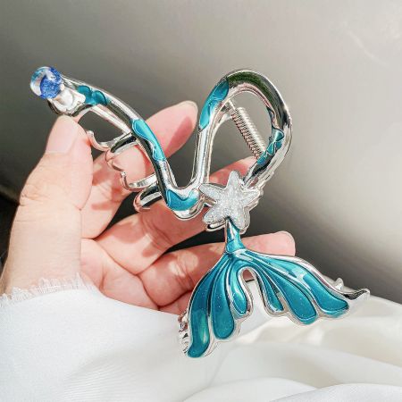 Detailed view of the mermaid hair clip with blue and white enamel and a starfish accent.